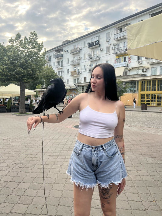 Девушка стоит на улице с птицей