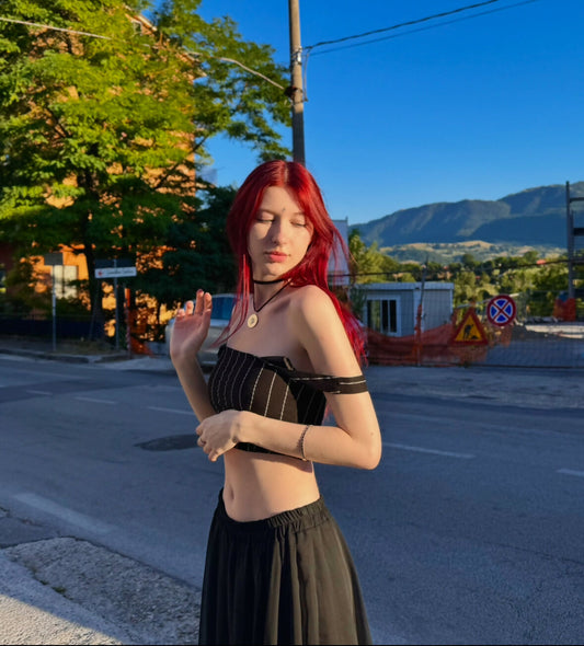 a girl with red hair is standing on the street